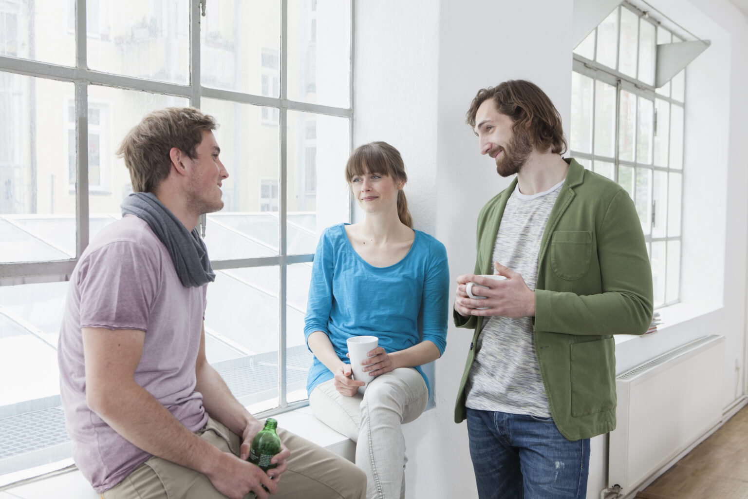 Three colleagues communicating in a creative office
